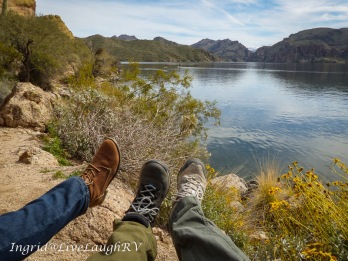 three different feet wearing hiking shoes photographed near a pristine lake near Phoenix, Arizona